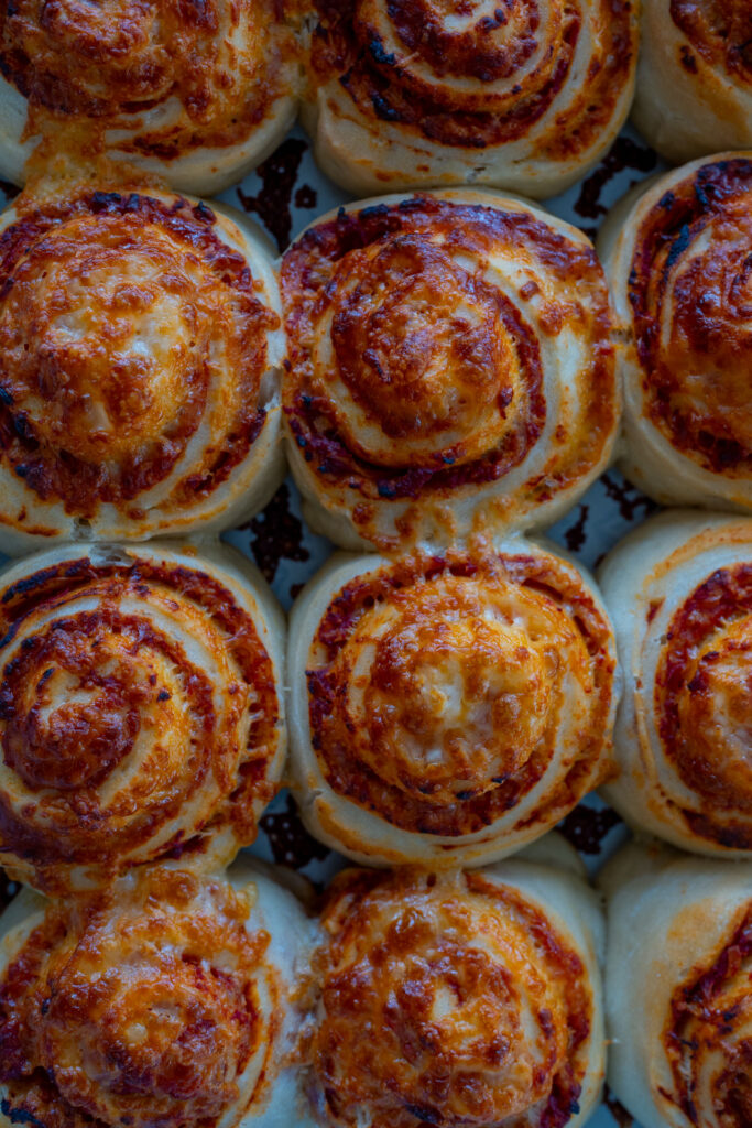 Luftig gebackene Pizzaschnecken mit geschmolzenem Käse in einer Auflaufform nach dem Rezept Mrs Flury